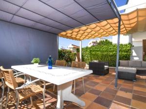 a table and chairs under an umbrella on a patio at Casa Socias in Comarruga