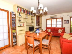 a living room with a table and a red couch at Casa Socias in Comarruga