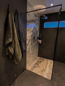 a shower with towels hanging on a wall in a bathroom at Exclusive Northernlight villa at Sørtromsøya in Tromsø +49 photos