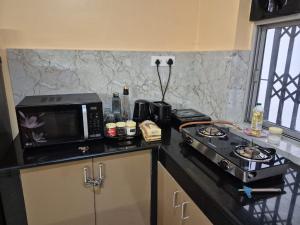 a kitchen with a stove and a microwave on a counter at Bliss Inn in Benaulim