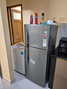 a refrigerator in a kitchen next to a washer at Bliss Inn in Benaulim