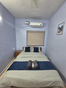 a bedroom with a large bed with blue walls at Bliss Inn in Benaulim +14 photos
