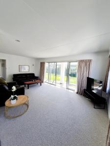 a living room with a couch and a table at 3 bedroom hidden gem in Gore