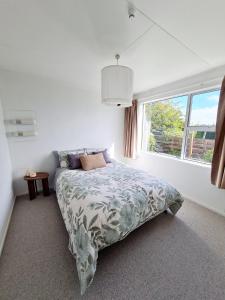 a white bedroom with a bed and a window at 3 bedroom hidden gem in Gore