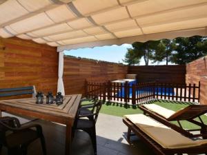 a patio with a table and chairs and a fence at Casa Rosalia in Roda de Bará