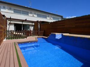 a swimming pool in front of a house with a wooden fence at Casa Rosalia in Roda de Bará