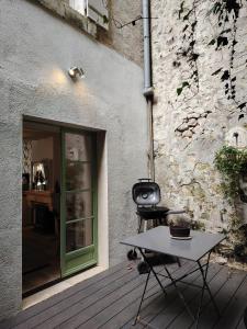 a grill and a table in front of a building at Nouveau - Maison de charme - Centre de Bourdeilles in Brantome en Perigord