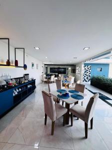 a dining room and living room with a table and chairs at Luster Hotel in João Câmara