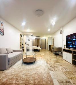 a living room with a couch and a tv at Brand new furnished studio Apartment near old Town in Phuket