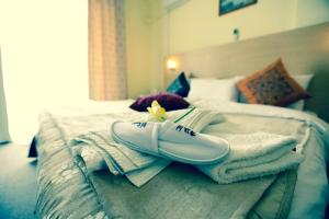 a bed with towels and a pair of shoes on it at Montreal Al Shobak Hotel - فندق مونتريال الشوبك in Al Jāyah +1 photo