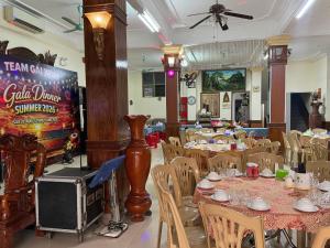 a dining room with tables and chairs and a sign at Hue Vinh Hotel in Thương Xà (2)