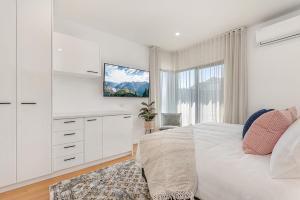 a white bedroom with a bed and a window at Gorgeous 3-Bed House with Spacious Shared Backyard in Carnegie