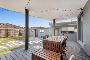 a patio with a wooden table and bench on a deck at Gorgeous 3-Bed House with Spacious Shared Backyard in Carnegie