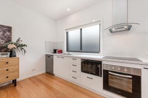 a kitchen with white cabinets and a window at Gorgeous 3-Bed House with Spacious Shared Backyard in Carnegie +11 photos