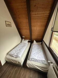 two beds in a small room with a window at Ferienhaus Hasenglück in Waldbrunn