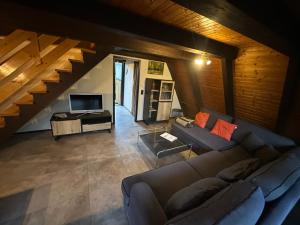 a living room with a couch and a television at Ferienhaus Eichhörnchennest in Waldbrunn