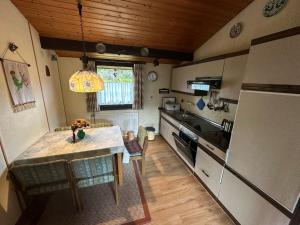 a small kitchen with a table and a refrigerator at Ferienhaus Morgentau in Waldbrunn
