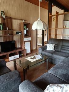 a living room with two couches and a coffee table at Ferienhaus Katzenbuckelblick in Waldbrunn