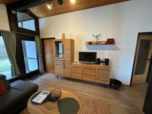 a living room with a couch and a tv at Ferienhaus Mooswinkel in Waldbrunn