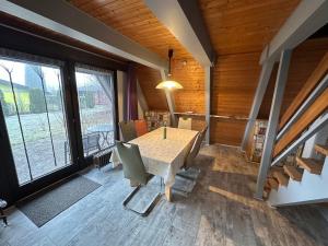 a dining room with a table and chairs and windows at Ferienhaus Schneekristall in Waldbrunn