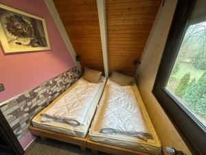 two beds in a small room with a window at Ferienhaus Schneekristall in Waldbrunn +13 photos