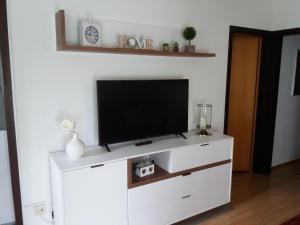 a white entertainment center with a flat screen tv on it at Ferienhaus Krappennest in Waldbrunn