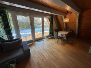 a living room with a table and a large window at Ferienhaus Glücksgefühle in Waldbrunn