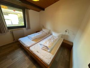 a small bed in a room with a window at Ferienhaus Abendstille in Waldbrunn +11 photos