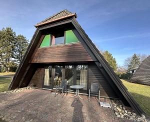 a house with a thatched roof with a table and chairs at Ferienhaus Winterruhe in Waldbrunn