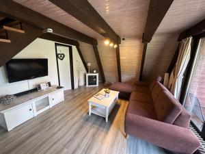 a living room with a couch and a tv at Ferienhaus Abendzauber in Waldbrunn