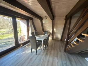a dining room with a table and chairs and windows at Ferienhaus Abendzauber in Waldbrunn