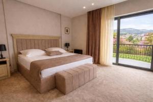 a bedroom with a large bed and a large window at Hotel Dilijan Resort in Dilijan +22 photos