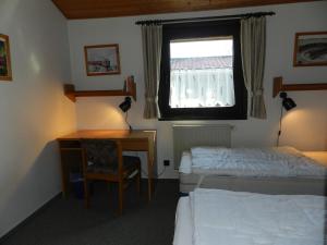a bedroom with two beds and a desk and a window at Ferienhaus Urlaubsfreude in Waldbrunn +14 photos