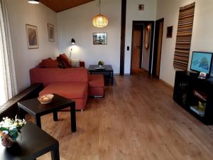 a living room with a red couch and tables at Ferienhaus Urlaubsfreude in Waldbrunn