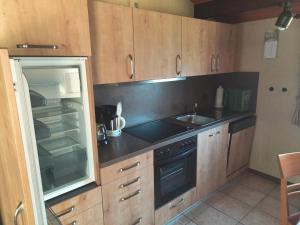 a kitchen with wooden cabinets and a sink and a stove at Ferienhaus Romantiklicht in Waldbrunn +12 photos