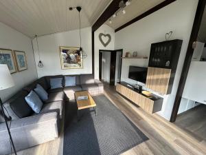a living room with a couch and a tv at Ferienhaus Gartenglück in Waldbrunn