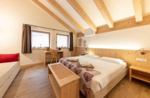 a bedroom with a bed and a couch at Hotel Chalet Serena in Roncegno