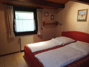 a bedroom with a bed and a window at Ferienhaus Romantiknest in Waldbrunn +12 photos