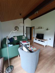 a living room with a green couch and a table at Ferienhaus Morgenrot in Waldbrunn