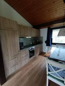 a kitchen with wooden cabinets and a table in a room at Ferienhaus Morgenrot in Waldbrunn