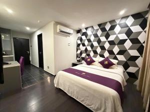 a bedroom with a large bed with a checkered wall at Mercury Boutique Hotel in Malacca +28 photos