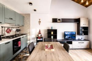 a kitchen with a wooden table and some chairs at IL CERVO - 2 camere, garage Dolomiti Affitti in Cavalese +22 photos