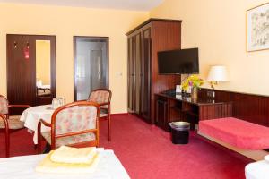 a hotel room with a bed and a flat screen tv at Hotel Marthahaus in Halle an der Saale