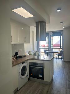 a kitchen with a washing machine and a living room at Hernández Central Park in Melilla