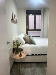 a bedroom with a bed with a table and a window at Hernández Central Park in Melilla