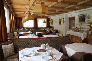 a dining room with tables and chairs and a restaurant at Garni Villa Linda in Corvara in Badia +12 photos