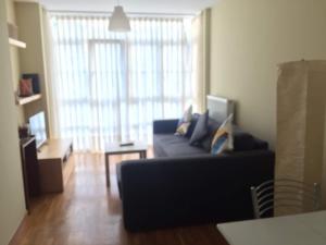 a living room with a couch and a large window at Apartamentos Ria de Foz in Foz