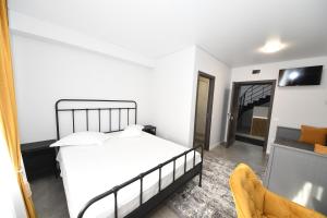 a white bedroom with a bed and a couch at Stay Inn in Galaţi