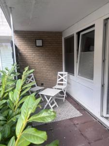 a white chair sitting on the porch of a house at Zentrale City Apartments in Oldenburg