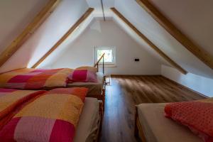 a attic room with two beds and a window at Alpine Daffodil Retreat in Jesenice